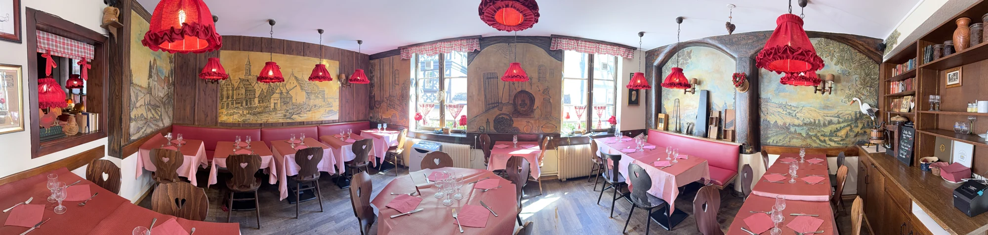 La salle et ses boiseries, éclairées par les lampes rouges