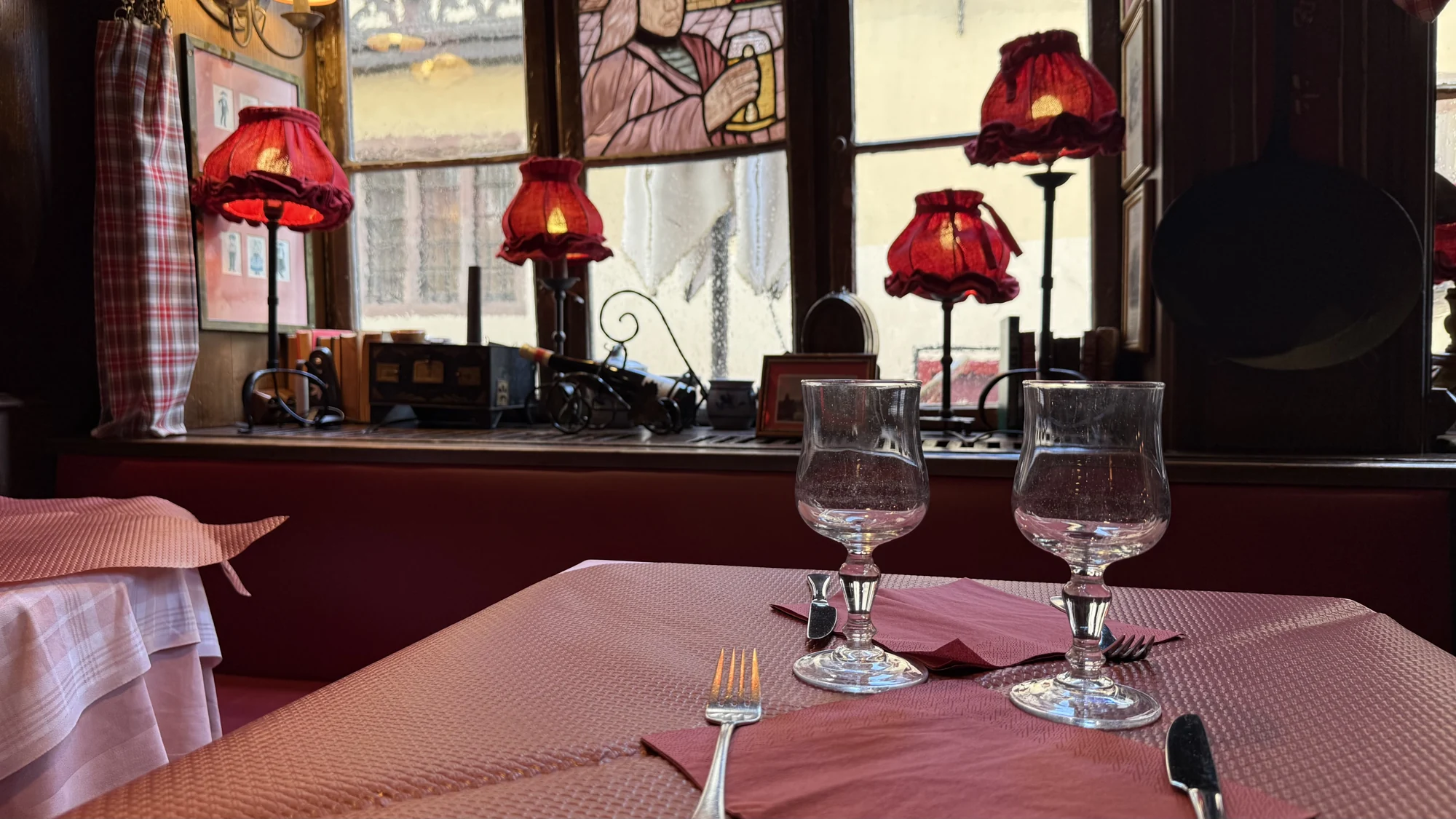 Une table dressée devant les vitraux du restaurant